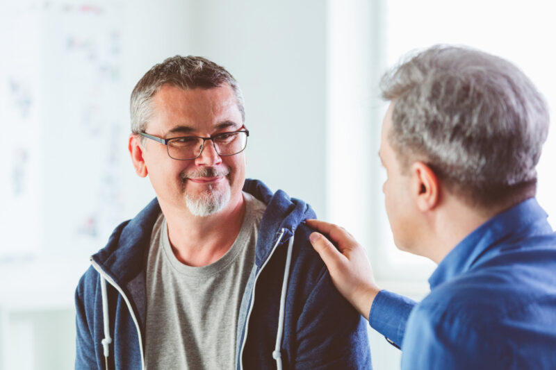 Mature man talking with psychotherapist in his office