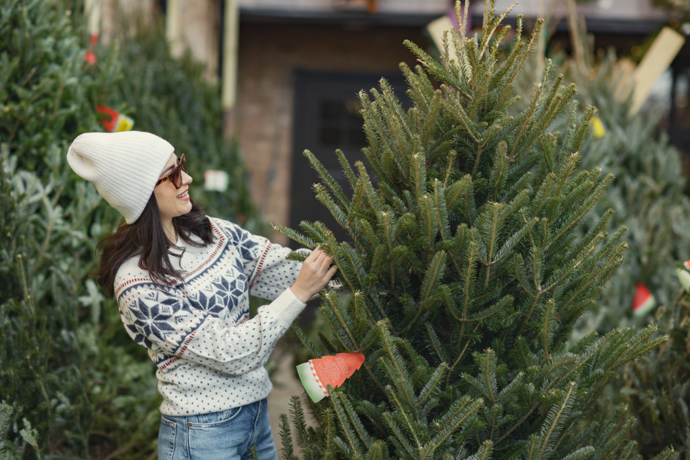 Cute brunette in a white sweater with Christmas tree
